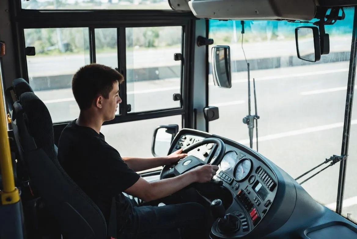 Cursist achter het stuur van een bus tijdens een rijles