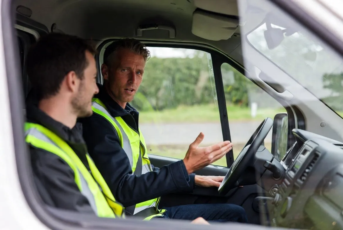 Rijinstructeur geeft uitleg aan een cursist achter het stuur